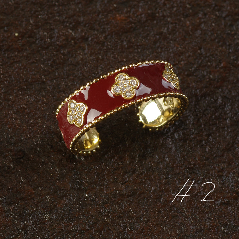 Red and gold brooch with floral designs on a dark brown background