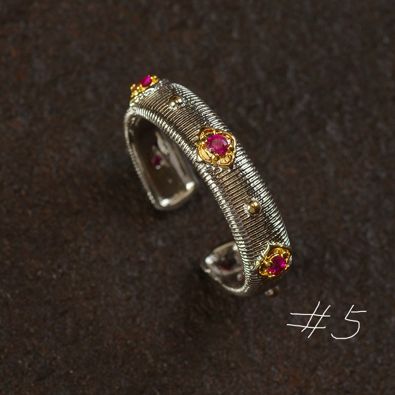 Silver cuff bracelet with gemstones on a dark brown background