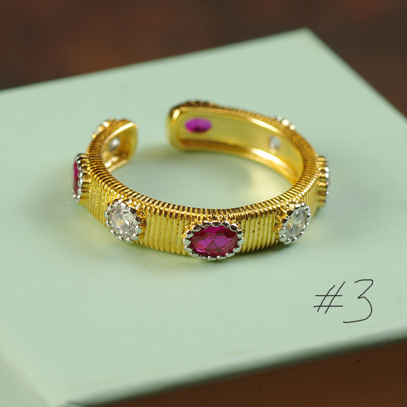 Gold bracelet with red and clear gemstones